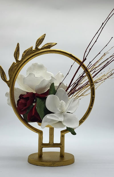 Gold circle hurricane leaf design filled with white /burgundy foam flowers and gold /burgundy branches