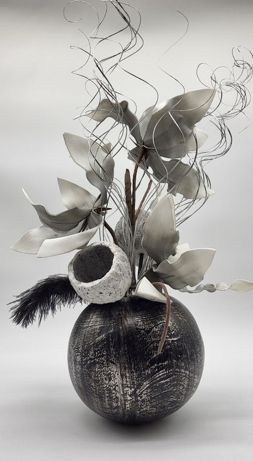 black/silver pot filled with grey foam flowers, black feather, silver branches