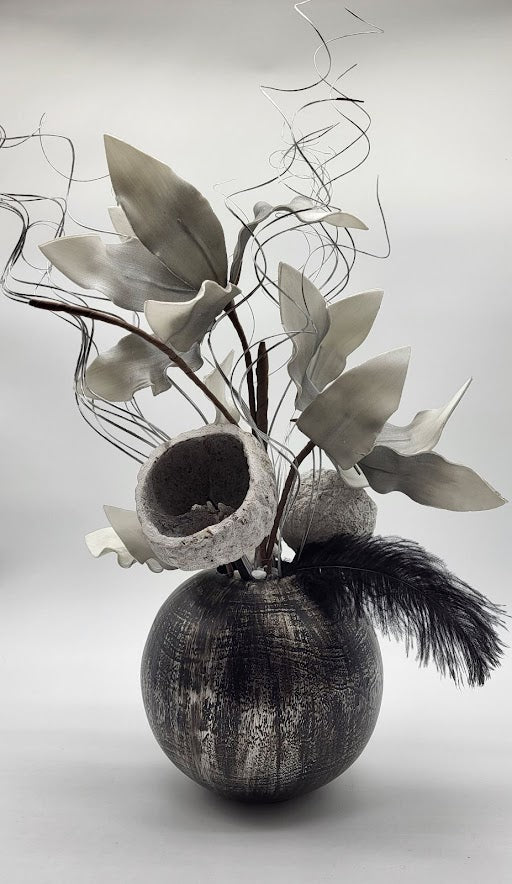 black/silver pot filled with grey foam flowers, black feather, silver branches