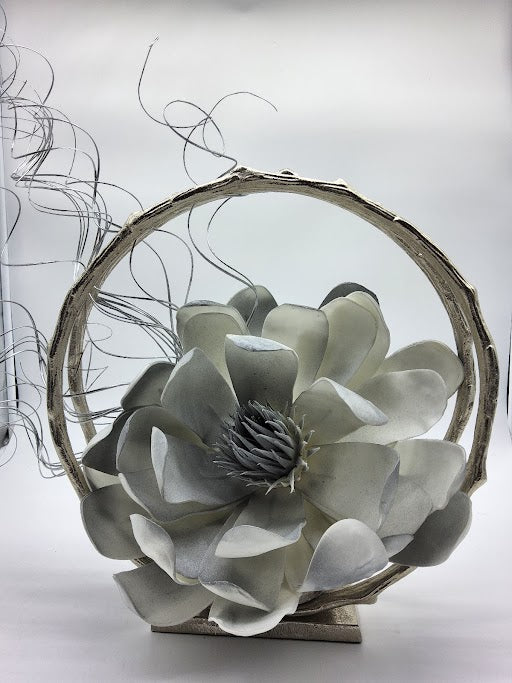 Silver circle hurricane filled with big grey foam flower and silver curly branches